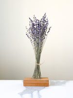 Load image into Gallery viewer, Lavender bunch staged in a wooden stand with a white and gray marble background.

